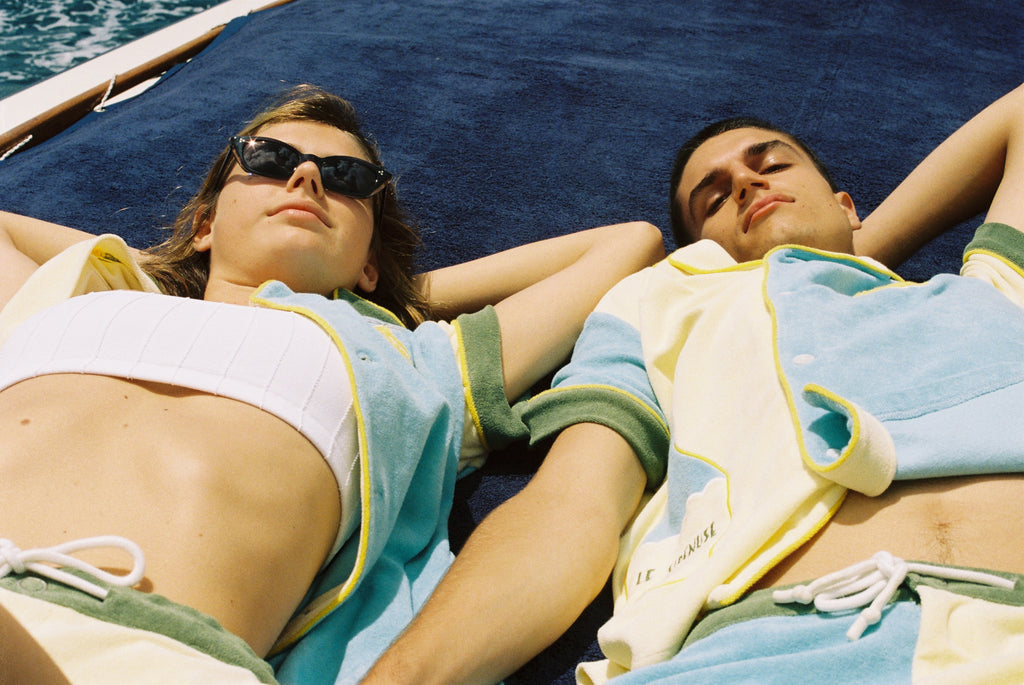 Male and female models lay on navy blanket on boat wearing limoncello set