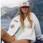 Female model wearing hat on a boat along with our Andiamo jacket