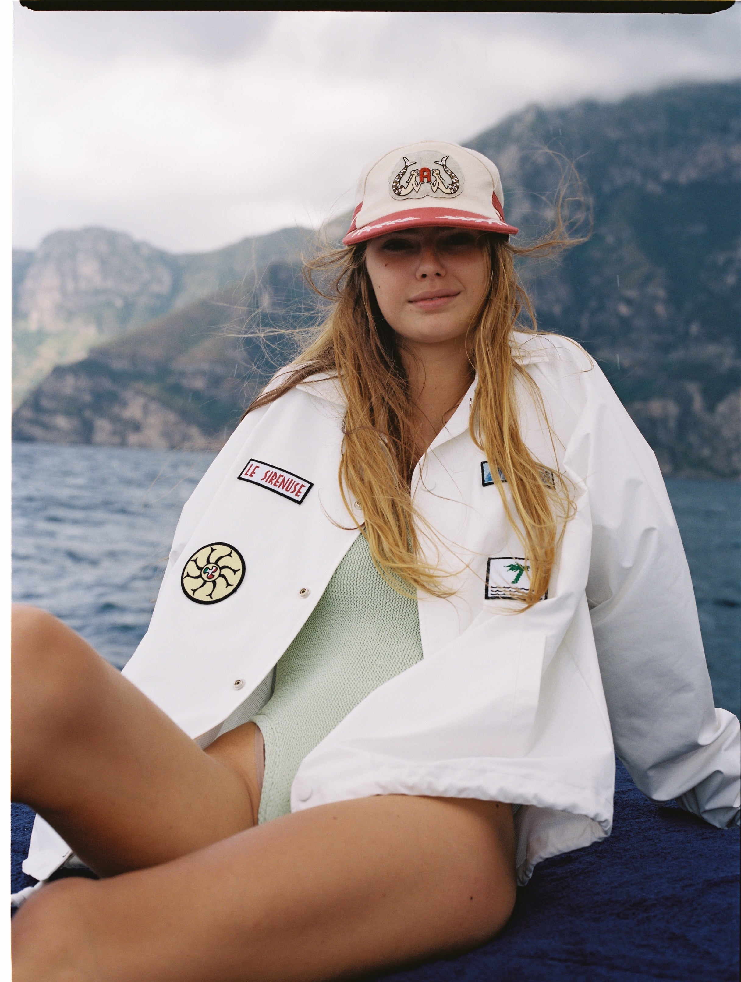 Female model wearing hat on a boat along with our Andiamo jacket