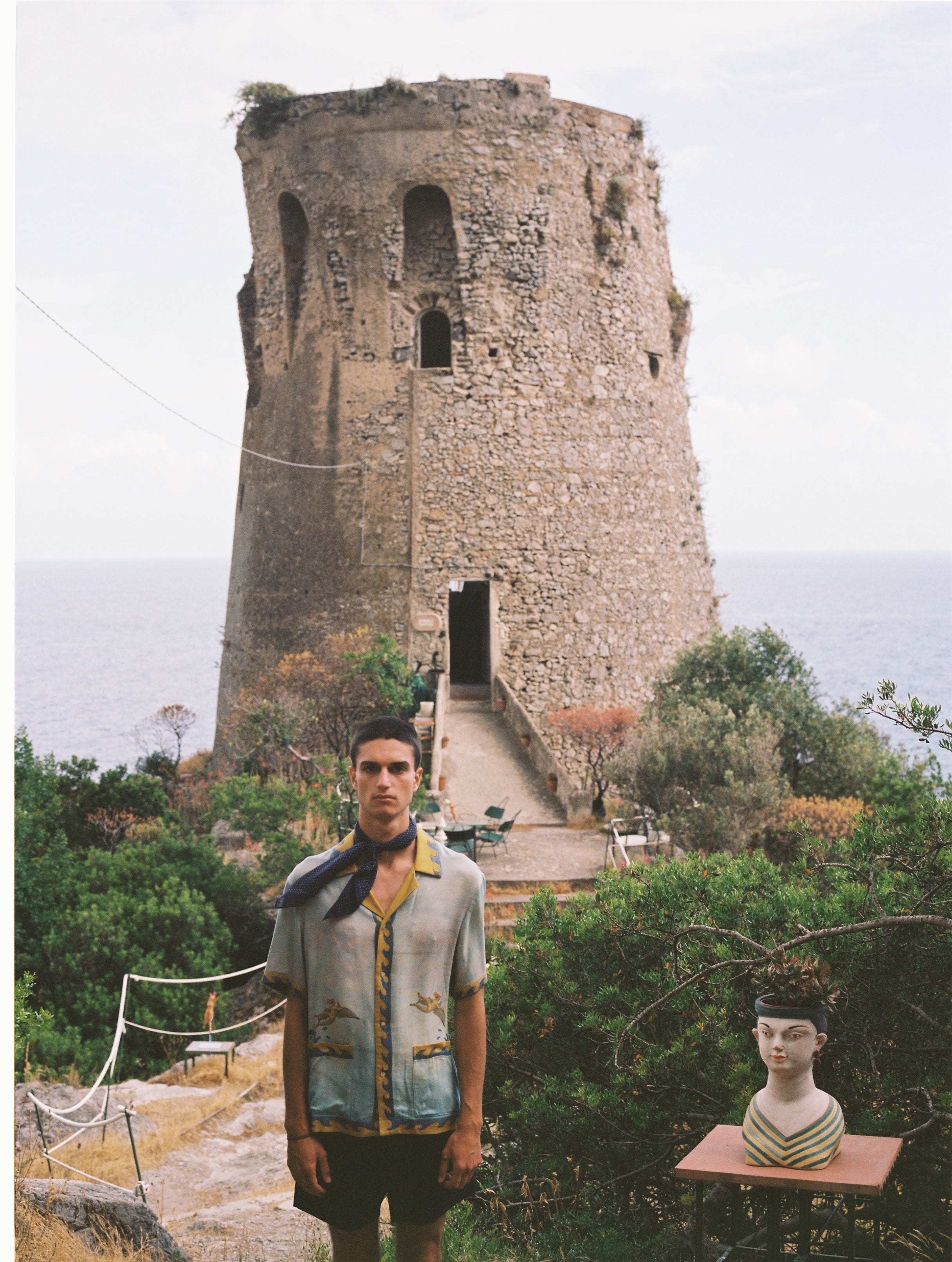 Male model wearing the shirt with shorts and an ascot outdoors