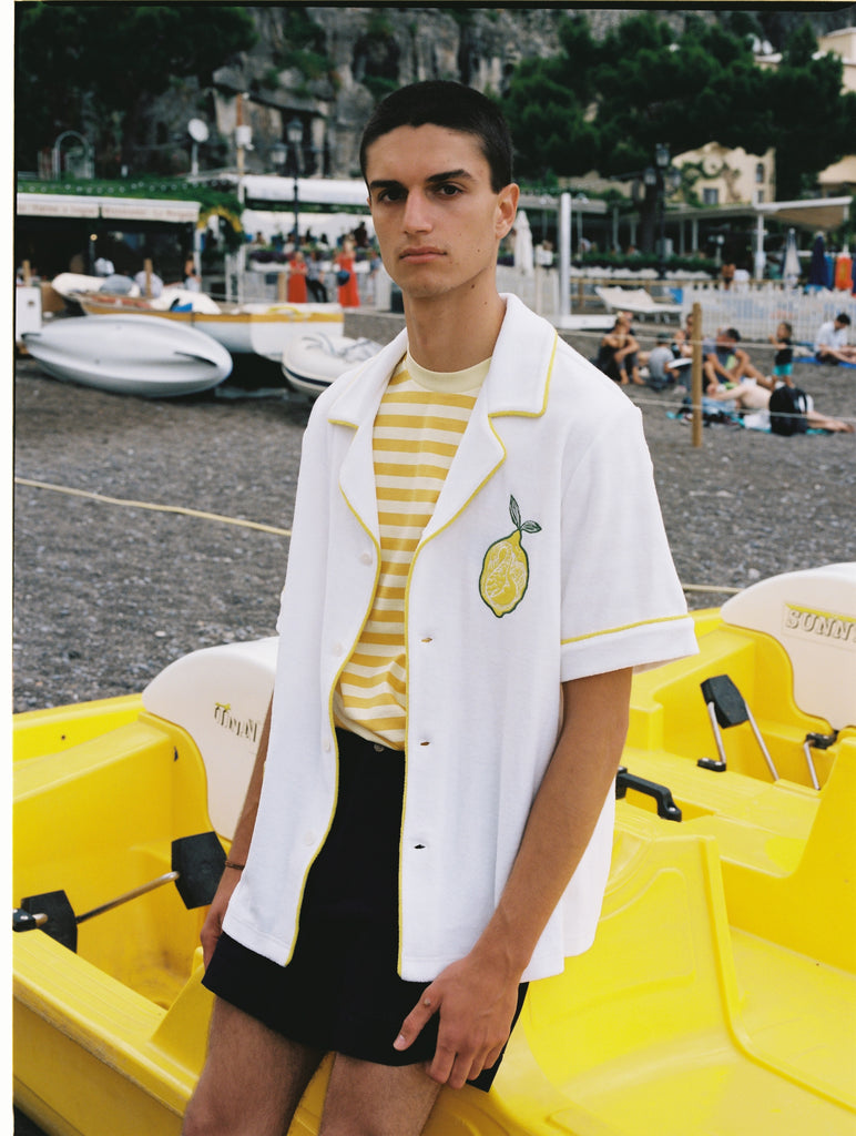 Man looks at camera leaning on small pedal boat