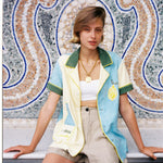 Female model wears limoncello shirt over a white cropped tank top and khaki colored shorts
