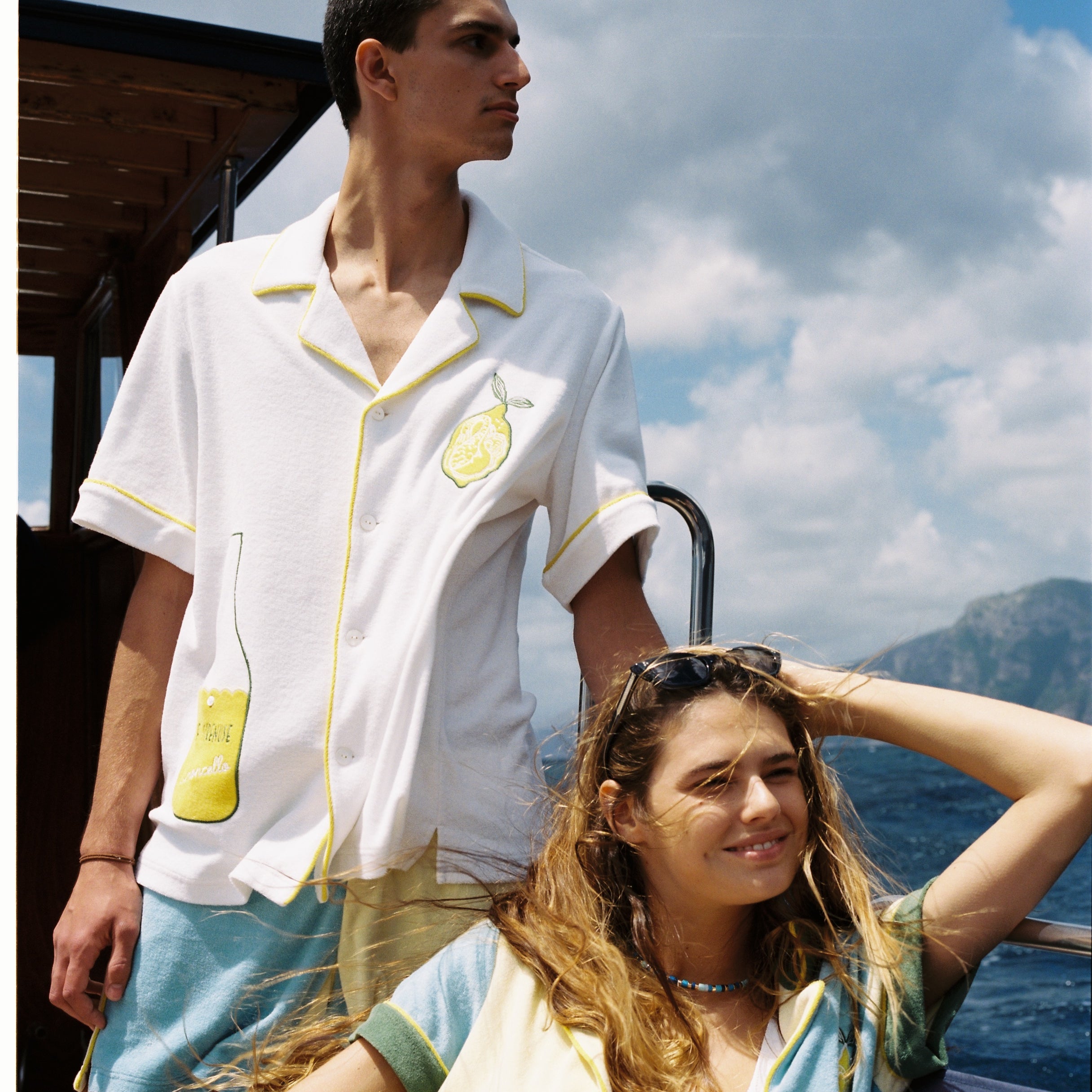 man and woman look off camera towards ocean