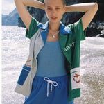 Female model with full set on beach with arms up on her head