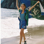 female model waving towel in the air on the beach