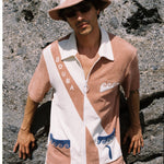 male model wearing full set leaning against a beachy rock