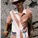 male model wearing full set leaning against a beachy rock