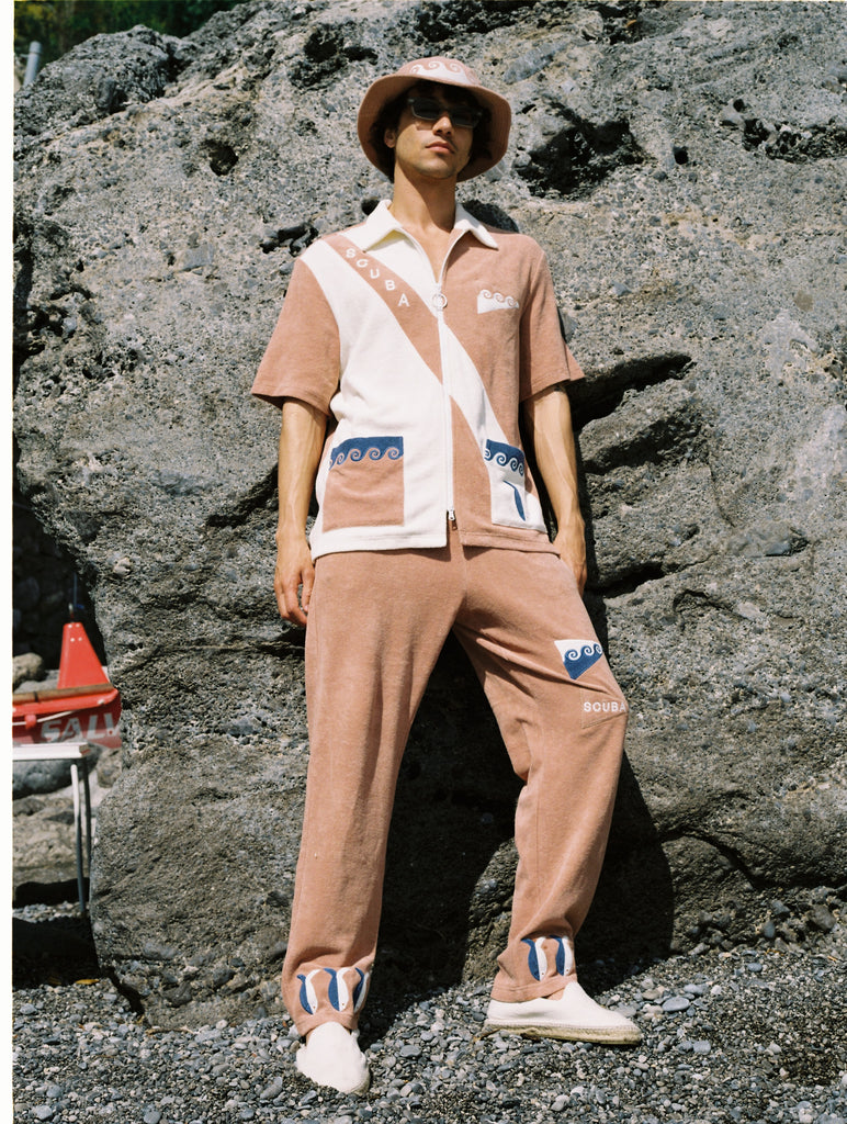 Man in full terry cloth matching set stares down at camera