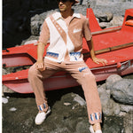 Male model posing on washed up boat in full set