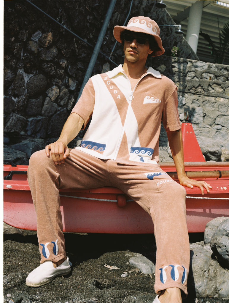 The matching pants and bucket hat complete this three-piece set, featuring waves, fish, and 'SCUBA' embroidery, all crafted from 100% organic cotton terry cloth