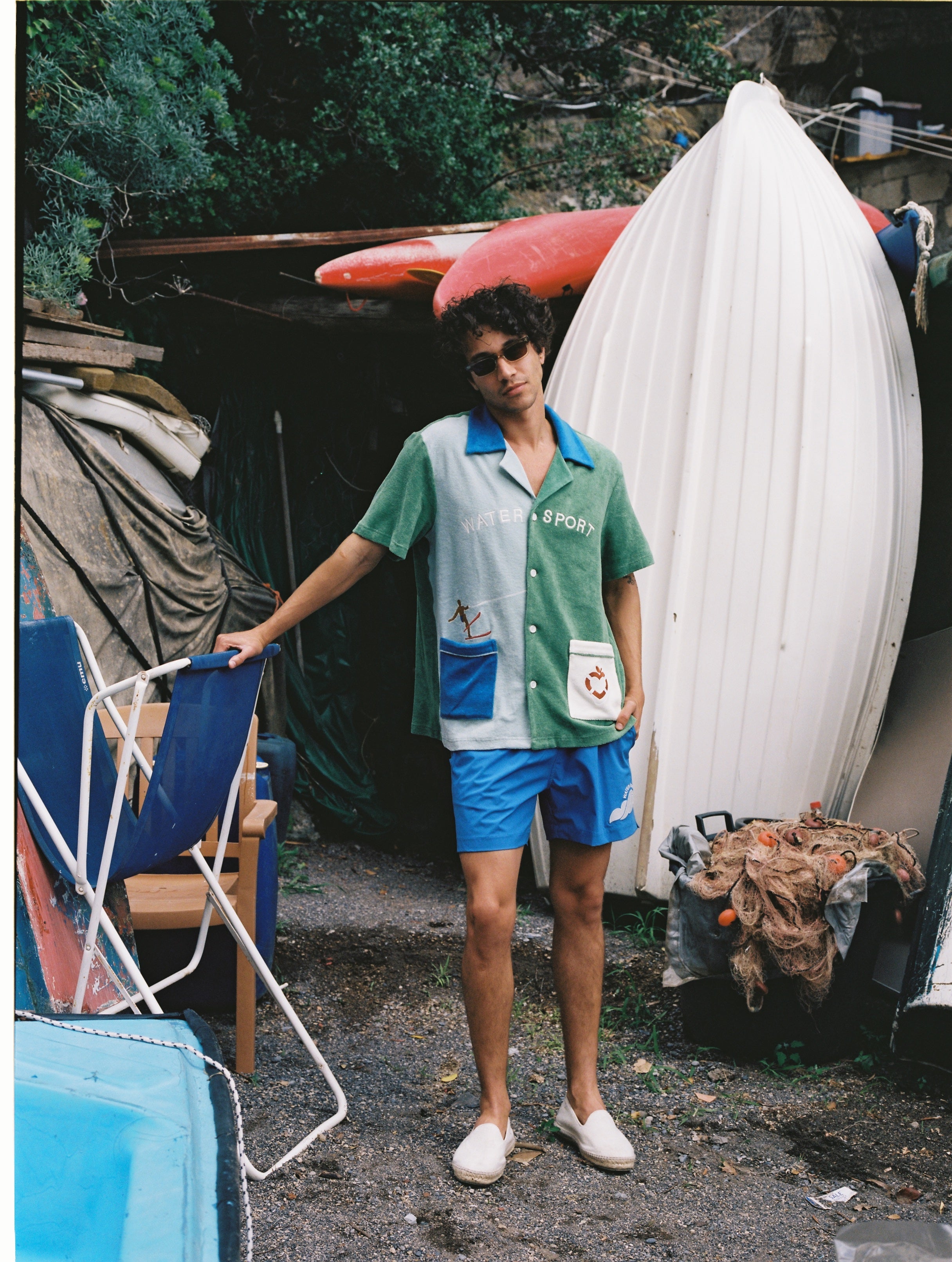Male model in full water sport set leaning his left arm on a beach chair