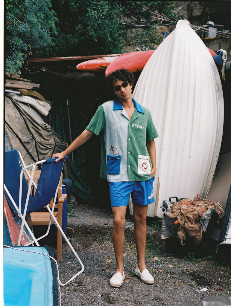 Male model in full water sport set leaning his left arm on a beach chair