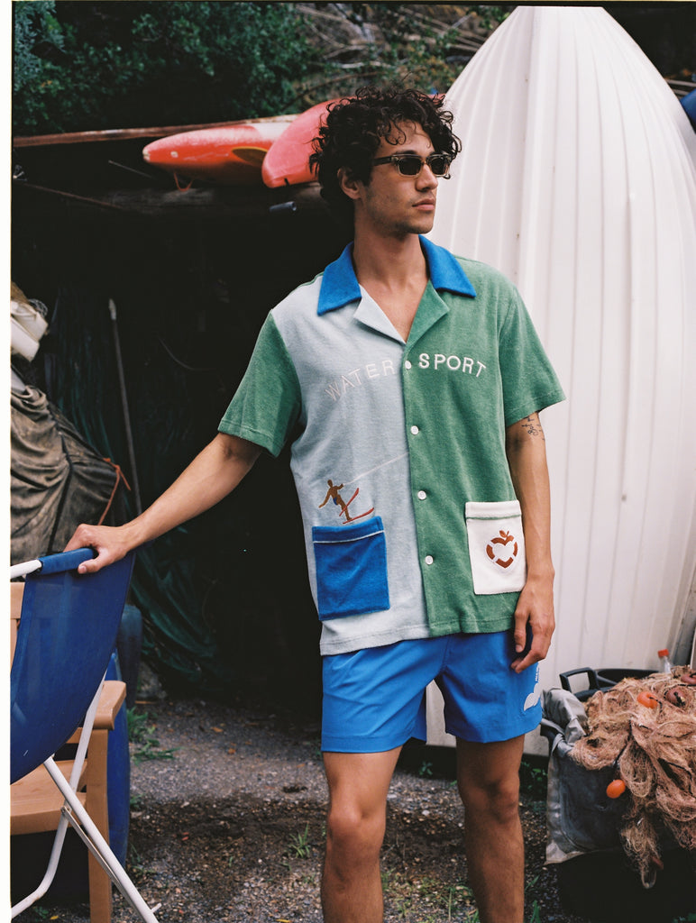Male model wearing full water sport set looking right and holding a chair