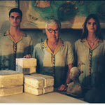 Paolo Sandulli alongside a male and female model, all three wearing the shirt dimly lit indoors