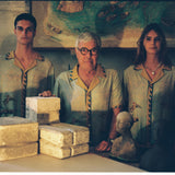 Paolo Sandulli alongside a male and female model, all three wearing the shirt dimly lit indoors