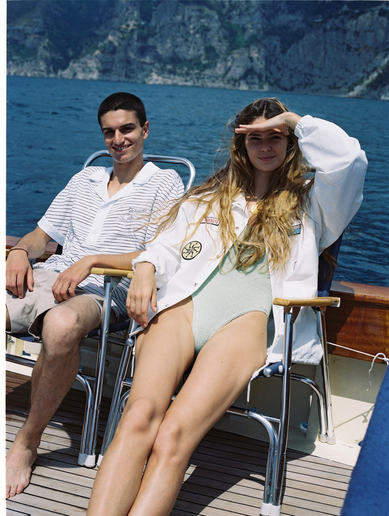 Female model with hands blocking sun from her eyes wearing the jacket on a boat