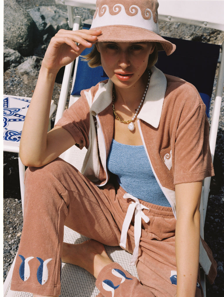 Woman holds bucket hat to shade her face