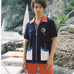male model standing in full dive set on rocky beach