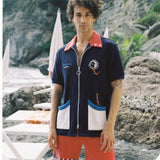male model standing in full dive set on rocky beach