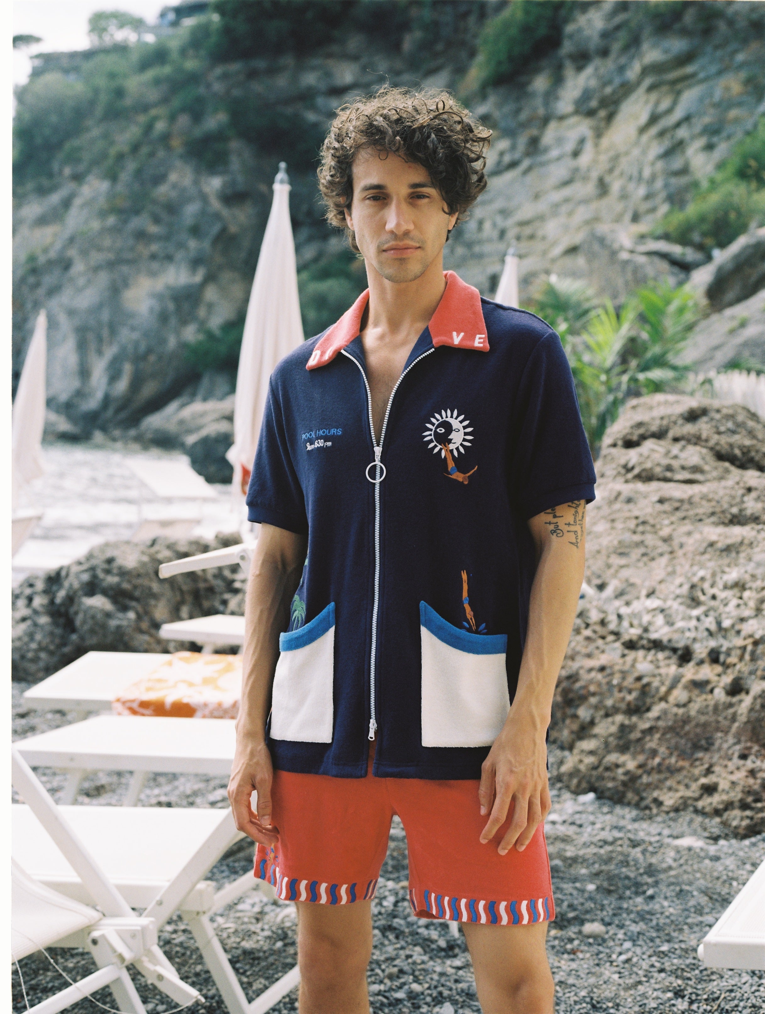 male model standing in full dive set on rocky beach