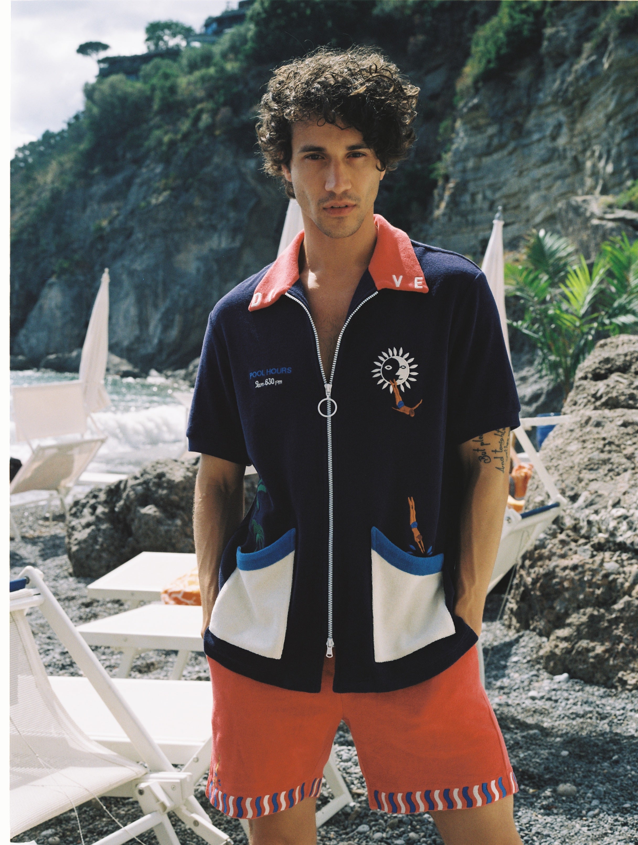 Male model wearing cabana looking at camera with hands in pockets