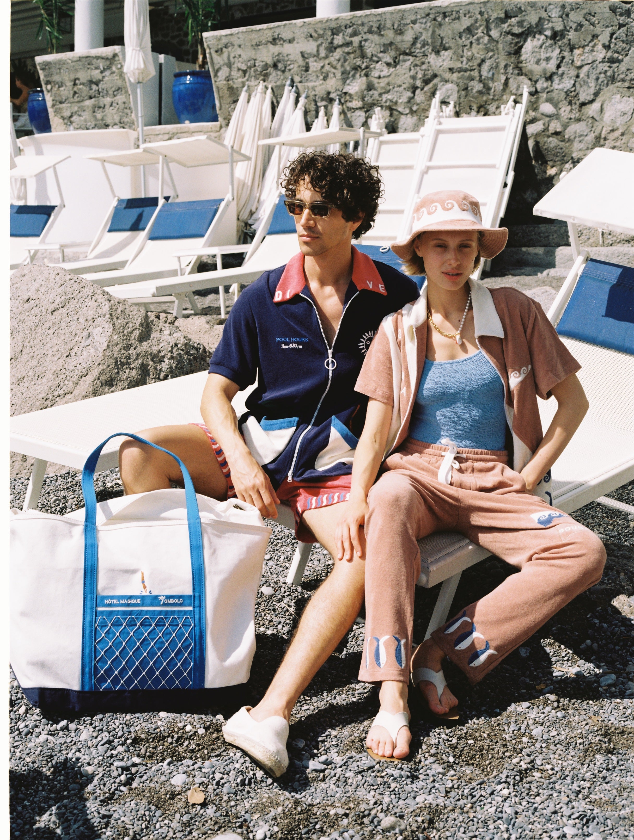 male model and female model sitting with tote bag on ground next to them
