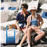 Male model next to female model in full set on beach chaise