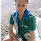 Female model looking up at camera sitting in cabana shirt