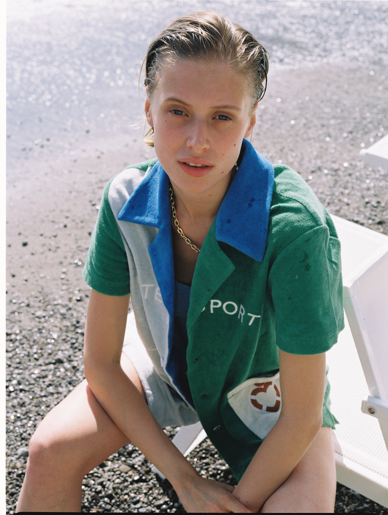 Female model looking up at camera sitting in cabana shirt