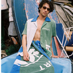 male model lounging on a boat in the water sport cabana and towel
