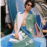 male model lounging on a boat in the water sport cabana and towel