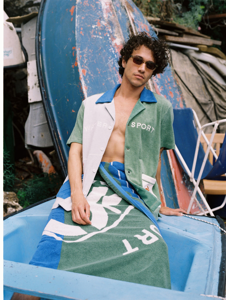 male model lounging on a boat in the water sport cabana and towel