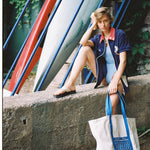 Female model wearing cabana holding hotel magique bag