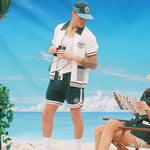 Man wearing full DSNY terry cloth set holds binoculars and stares at woman reading brochure