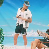 Man wearing full DSNY terry cloth set holds binoculars and stares at woman reading brochure