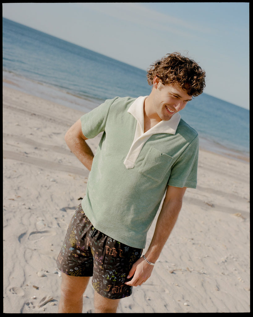 Man looks down to his left on the beach