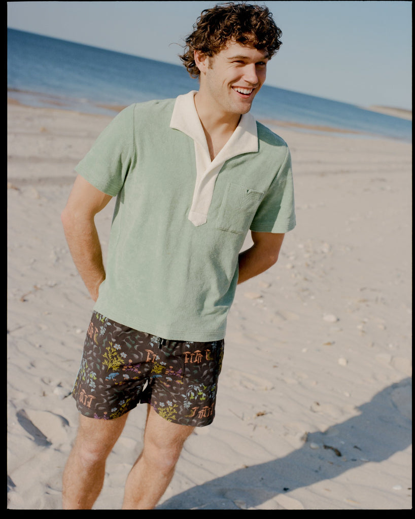 Man wearing green polo on the beach