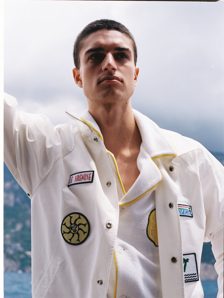 Male model wearing jacket unbuttoned on a boat