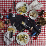 Shirt haphazardly placed on a dinner table surrounded by various italian foods and drinks