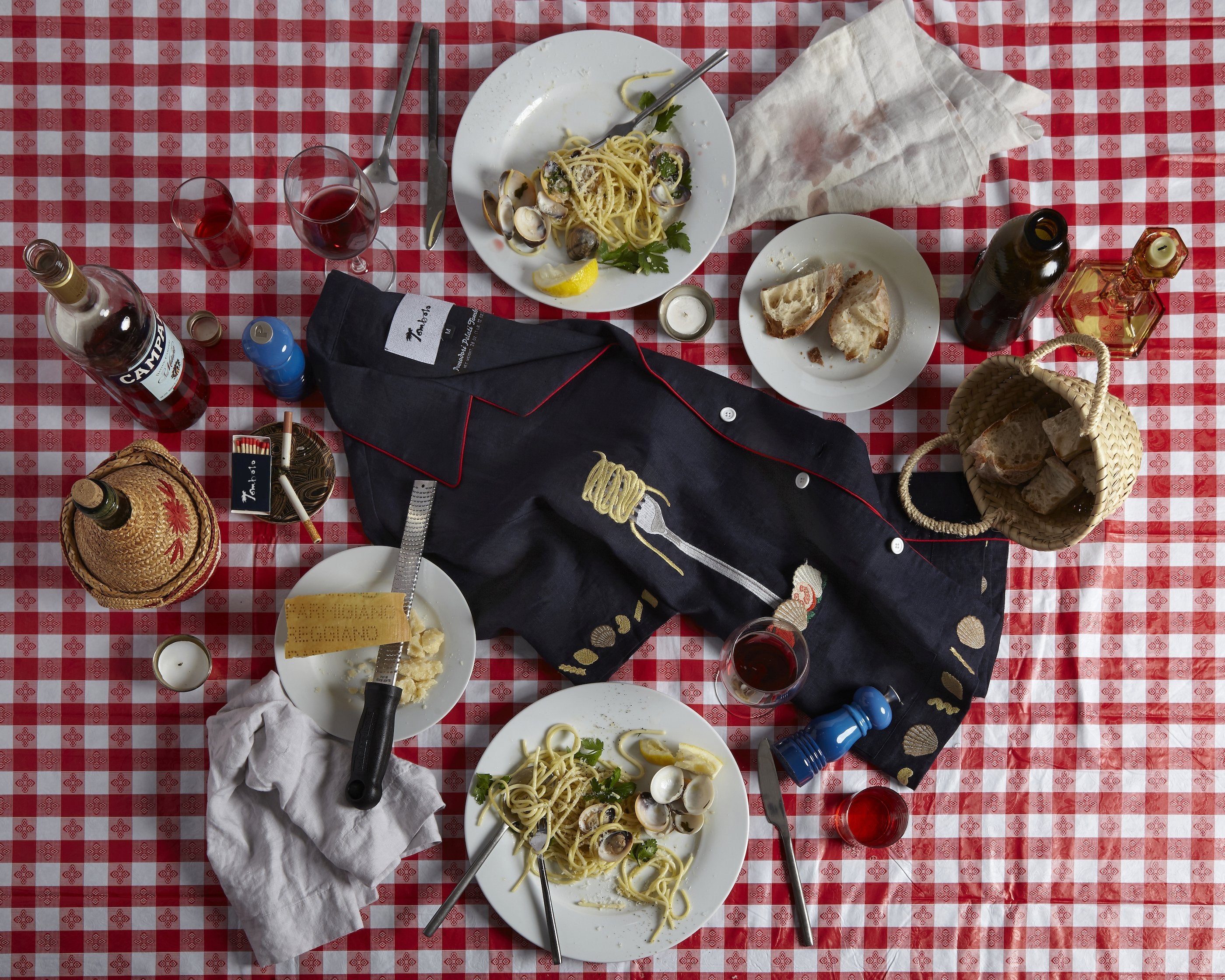 Shirt haphazardly placed on a dinner table surrounded by various italian foods and drinks