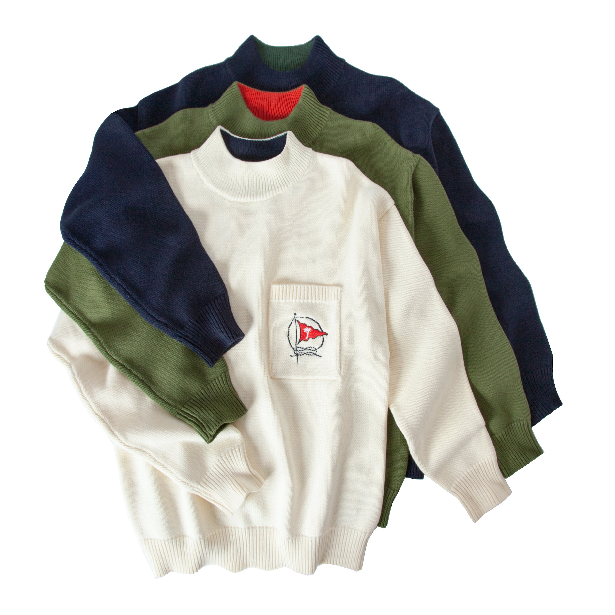 Three different colorways of sweater in navy, cream and green lay on top of eachother