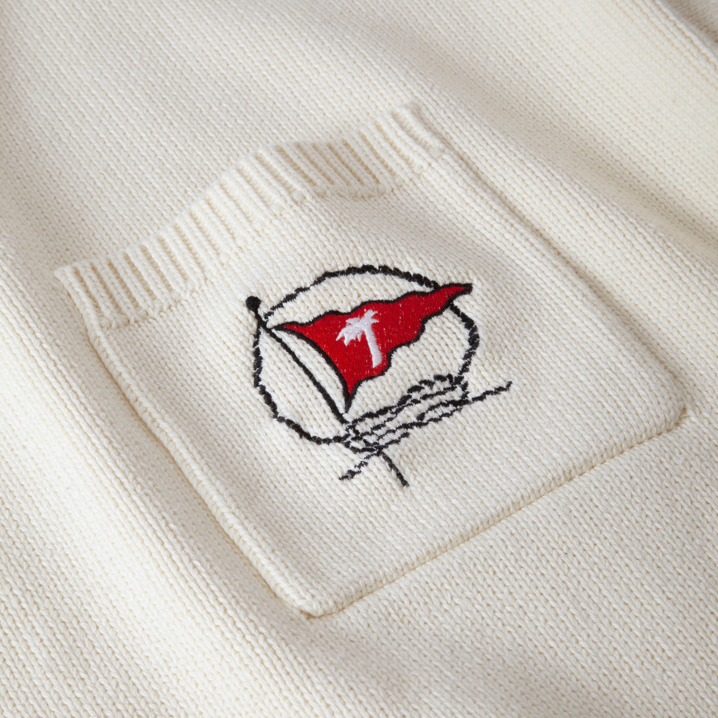 Close up of embroidered red flag with Tombolo logo on pocket