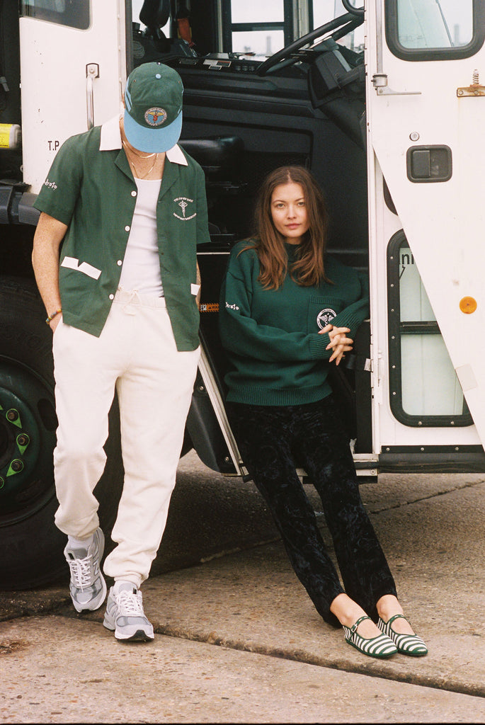Man and woman sitting on steps of DSNY truck