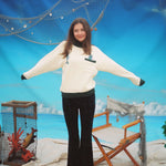 Female model wearing the sweater stretching out her arms