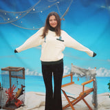 Female model wearing the sweater stretching out her arms