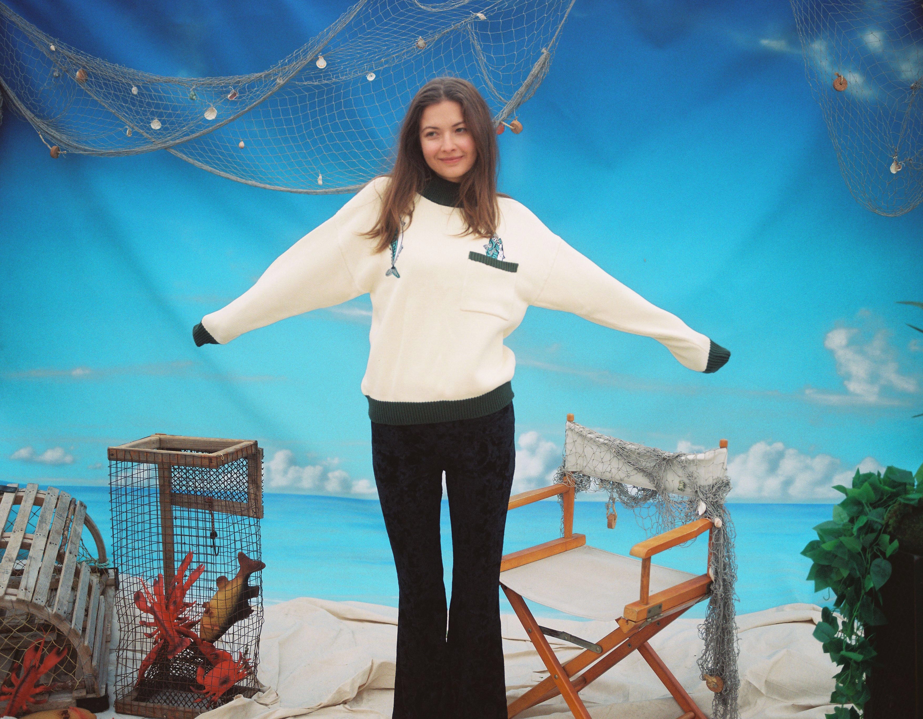 Female model wearing the sweater stretching out her arms