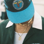 Male model looking down wearing cap with the DSNY Hawaiian