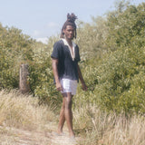 Man wearing unbuttoned polo standing in sand dune