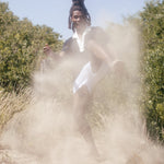 Man makes kicking motion as sand flies around the frame