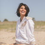Female model smiling in the sun leopard cabana sitting on a grassy beach